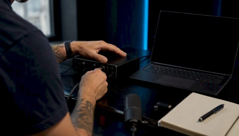 Hands connecting microphone cable in editing studio
