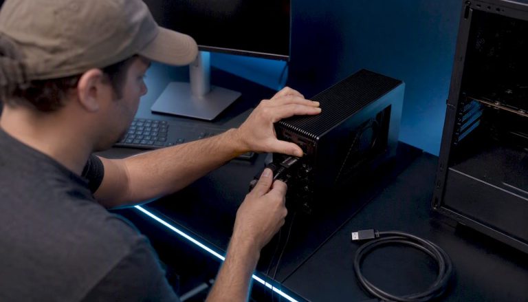Hands connecting external GPU for video editing