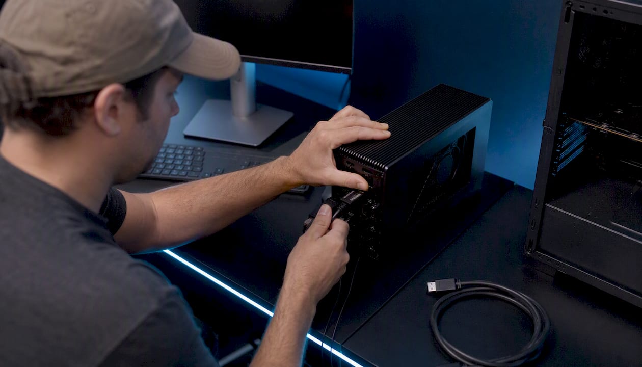 Hands connecting external GPU for video editing