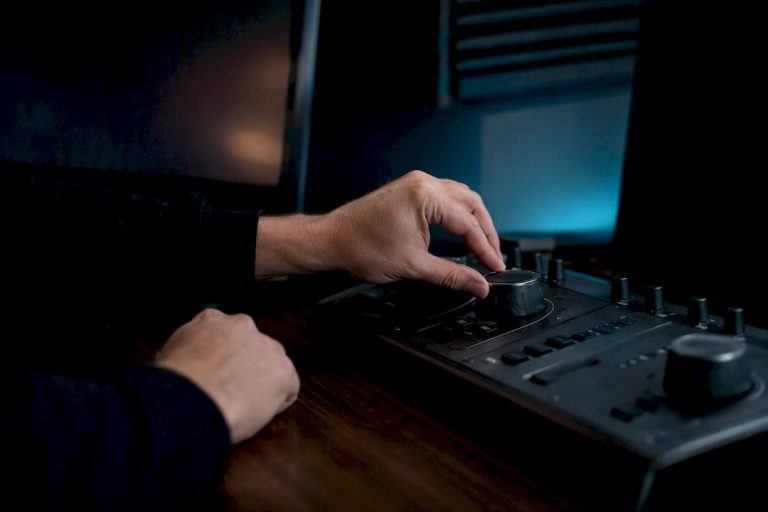 Hands adjusting noise reduction knob on console