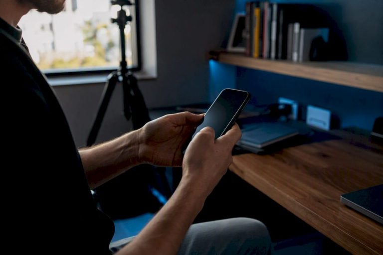 Hands editing video on smartphone in creative space